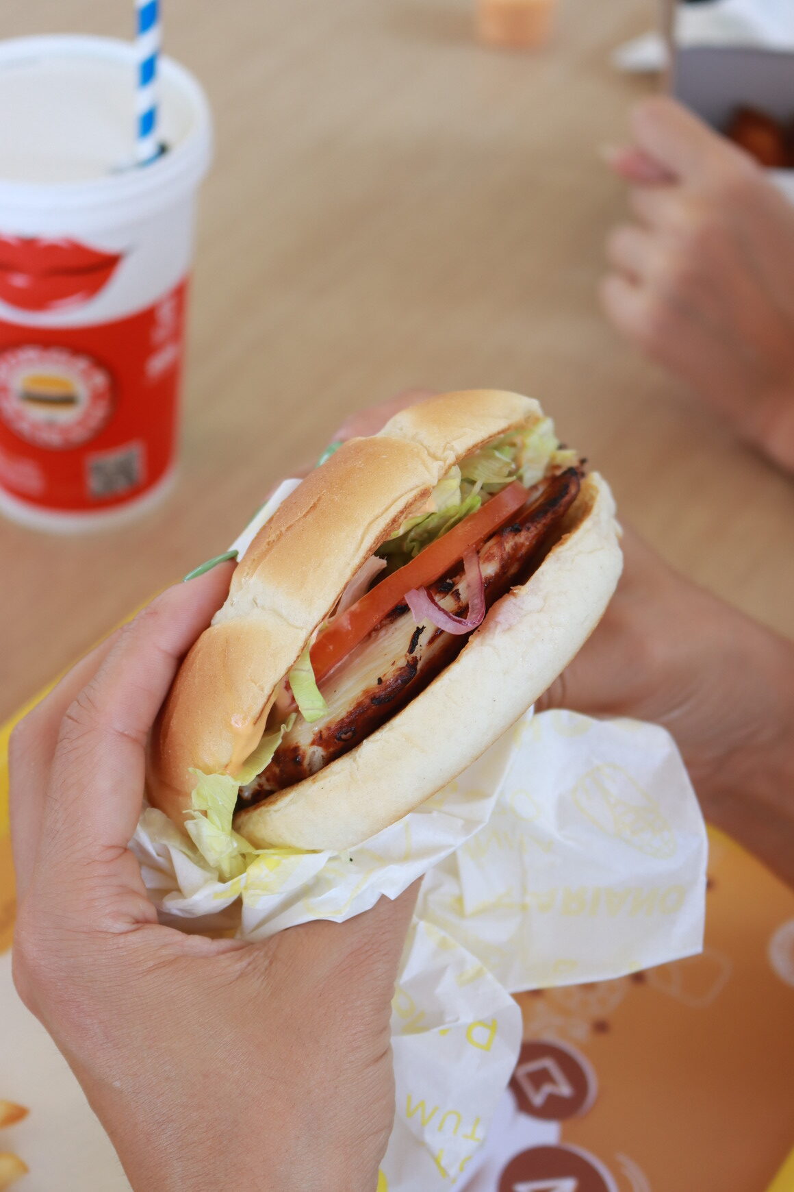 Pessoa a segurar um hamburger de queijo